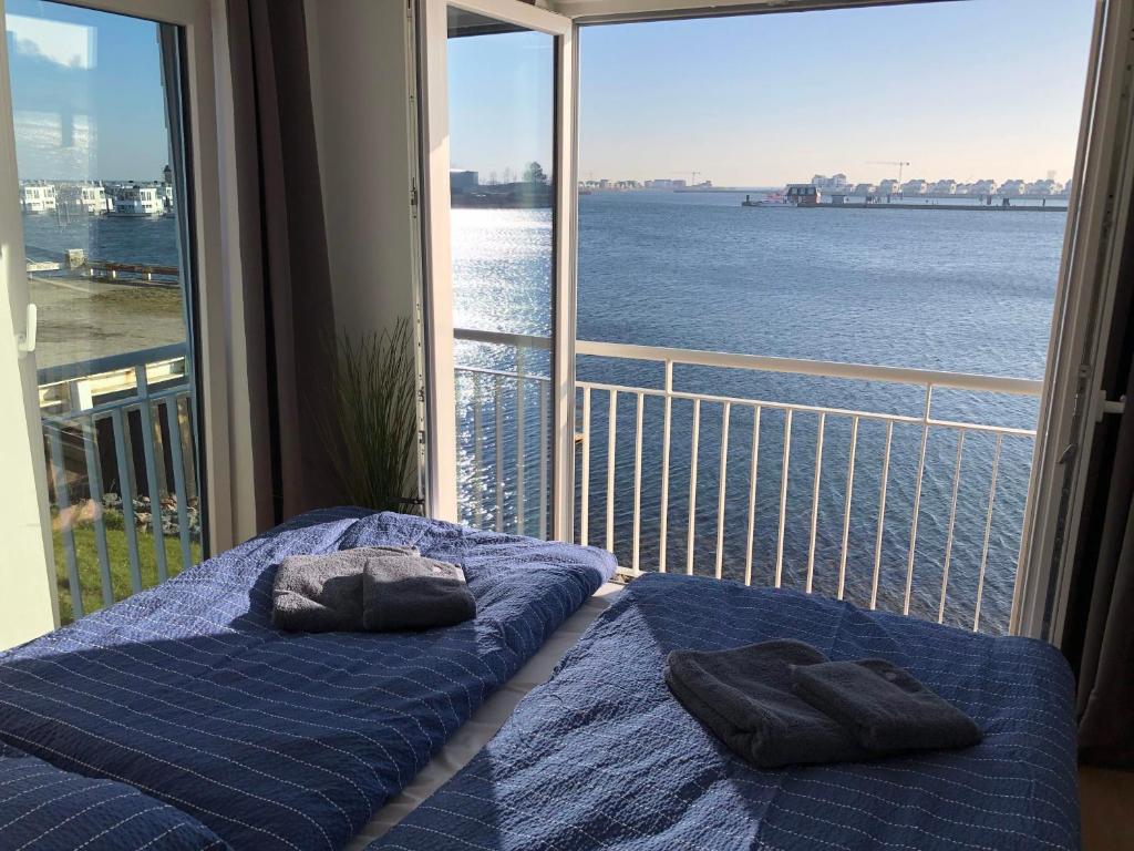 a balcony with two beds and a view of the water at Schleivilla Hafenmeister in Kappeln