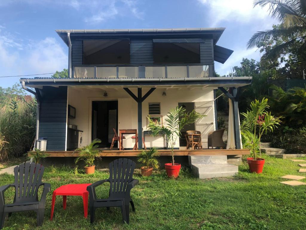 una casa azul con sillas y mesa en Agréable appartement à 2 pas des plages, en Le Gosier