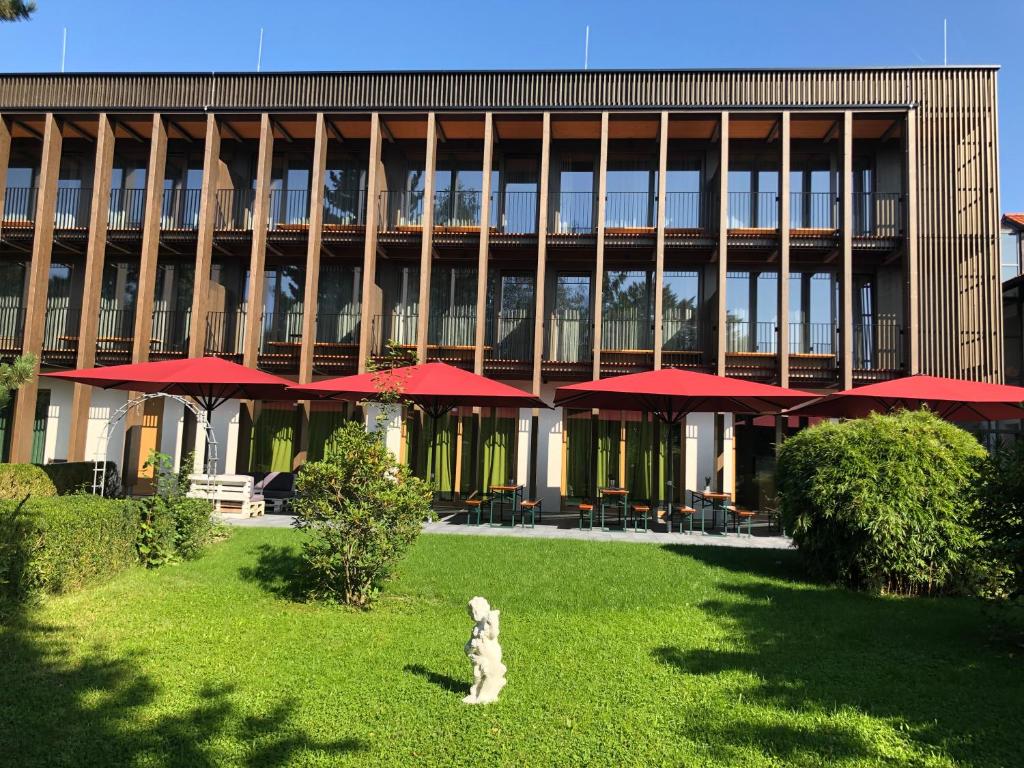 einem Hund, der im Gras vor einem Gebäude sitzt in der Unterkunft Gasthof-Hotel Höhensteiger in Rosenheim