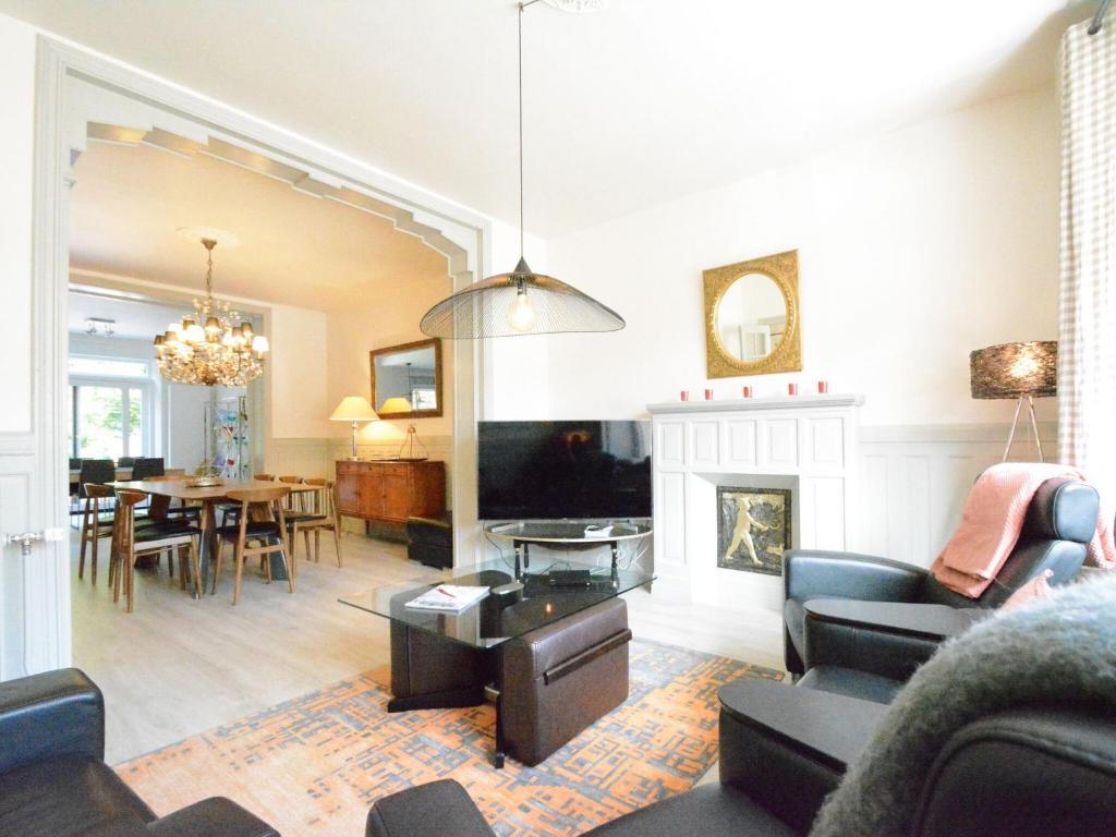 a living room with a fireplace and a dining room at Large townhouse with pool table in Bouillon