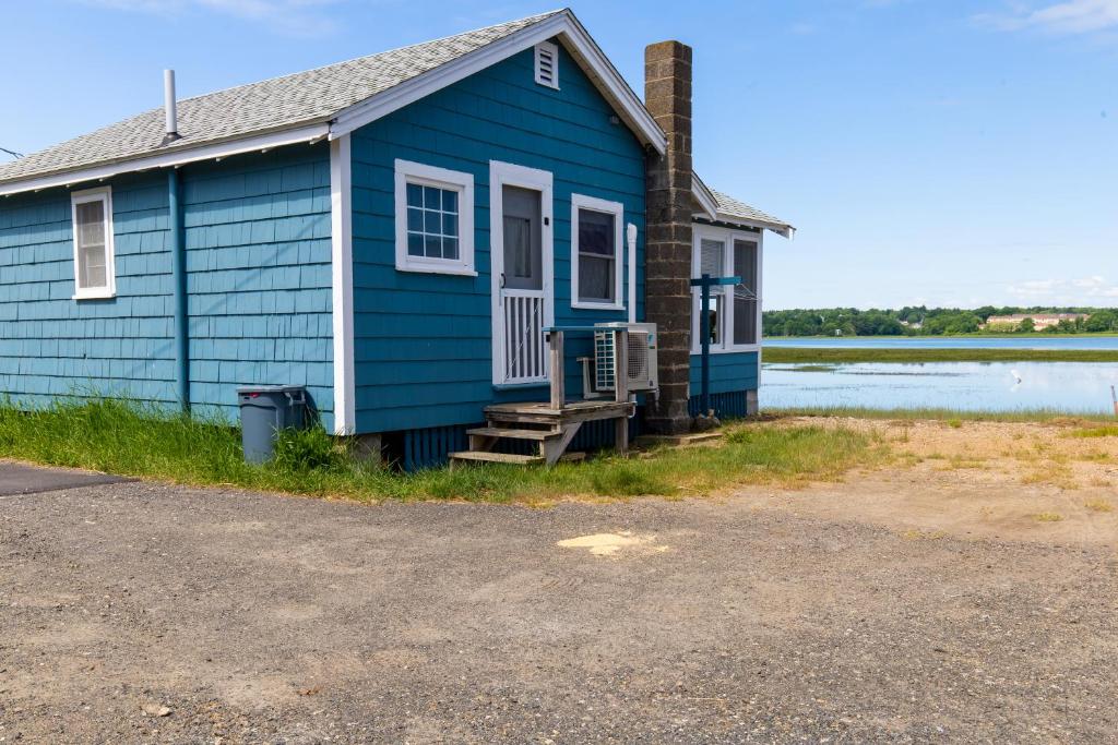 een blauw huis naast een waterlichaam bij The Eastern Avenue Cottage in Wells Beach