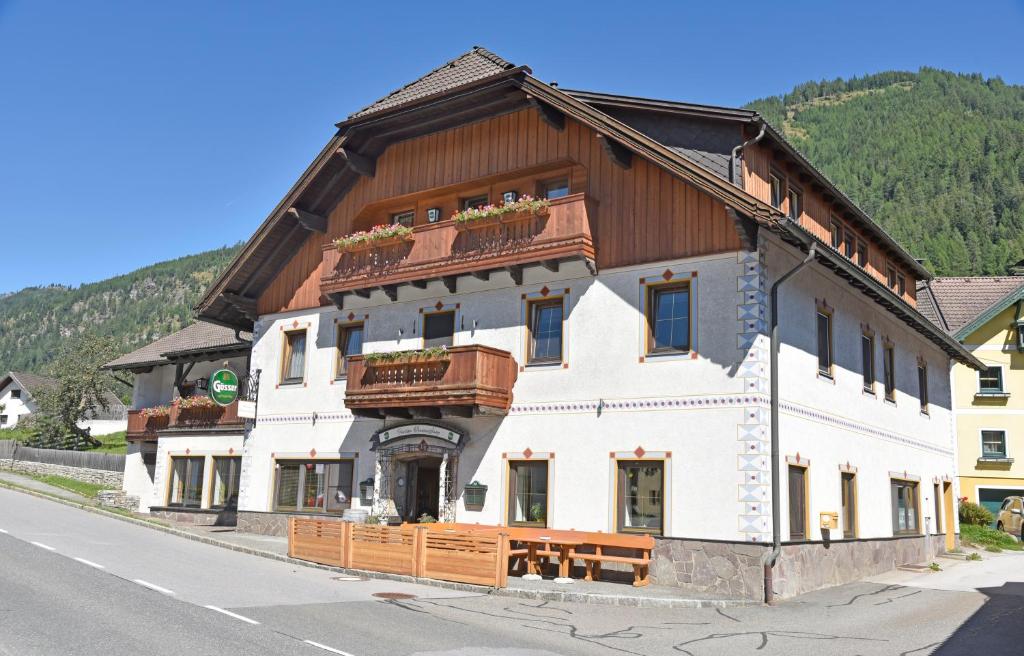 a large white building with a wooden roof at Frühstückspension Oberweissburg in Sankt Michael im Lungau