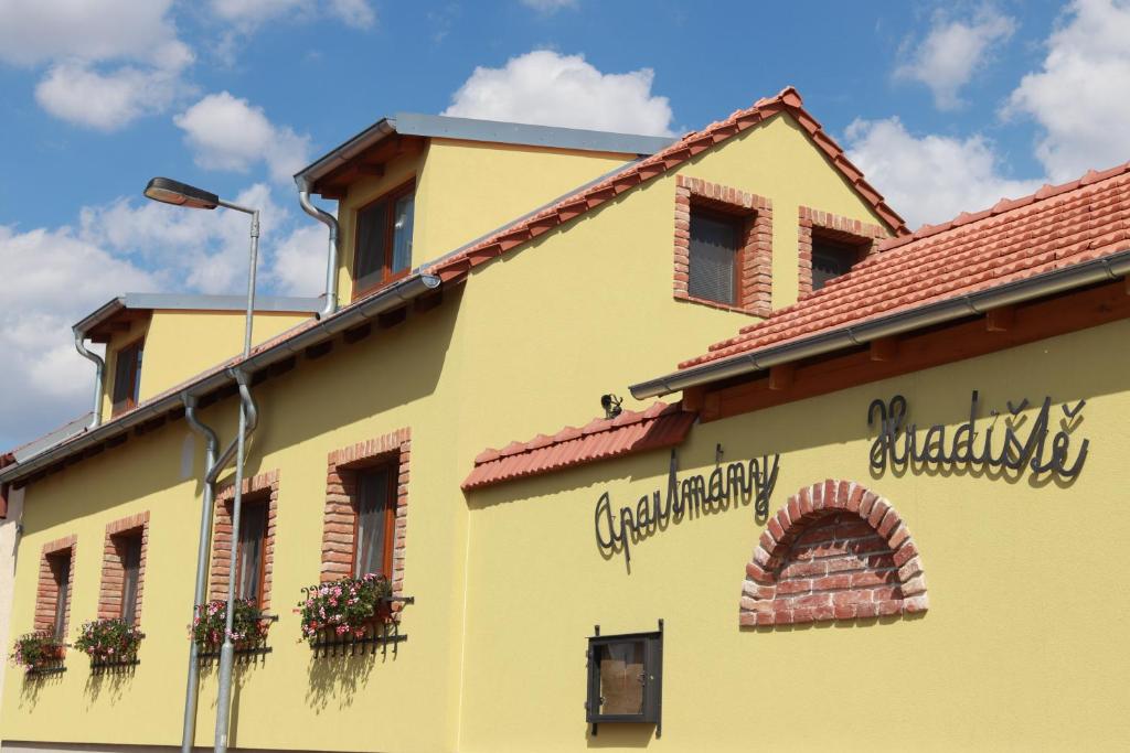 um edifício amarelo com flores ao lado em Apartmány Hradiště em Znojmo