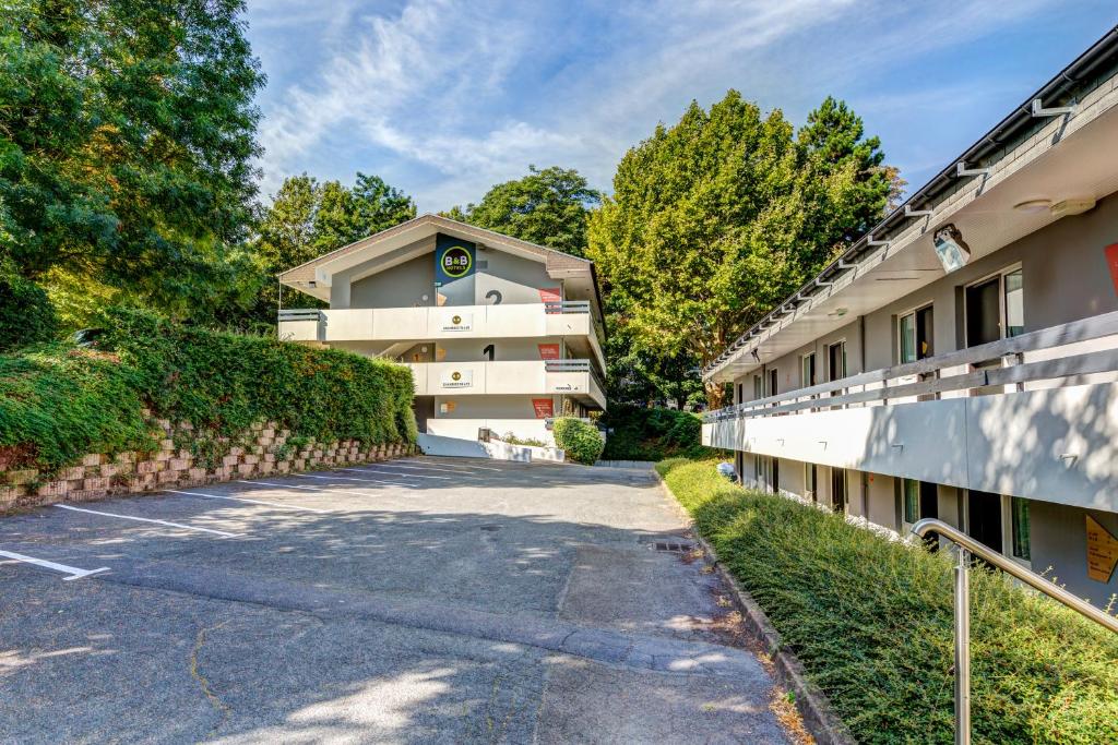 a building with a road in front of it at B&B HOTEL Louveciennes in Louveciennes