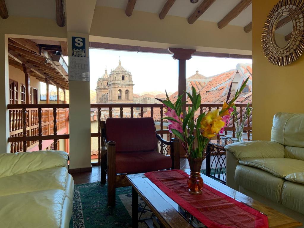 uma sala de estar com uma mesa e vista para um edifício em Amerindia em Cusco