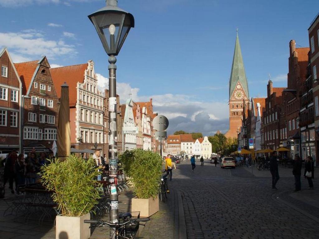 eine Stadtstraße mit Gebäuden und einer Straßenbeleuchtung in der Unterkunft HOTEL alt lüneburger Kutscherstuben in Lüneburg