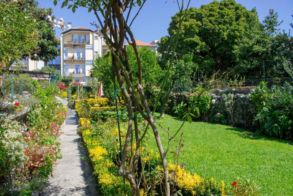 un jardín con flores y un edificio de fondo en Hotel Estoril Porto, en Oporto