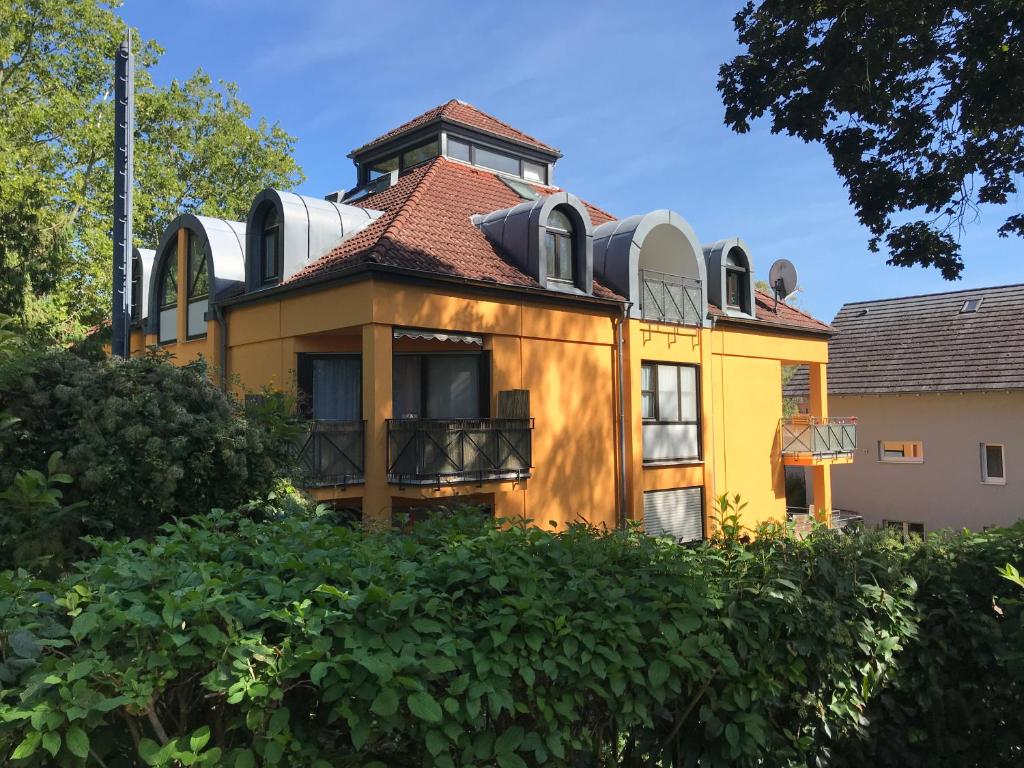 ein gelbes Haus mit einem Turm darüber in der Unterkunft Maisonette am Belchen in Bad Krozingen