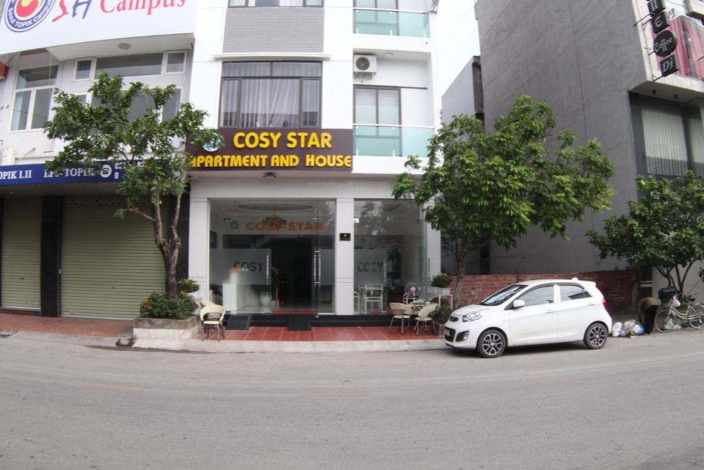 um carro branco estacionado em frente a um edifício em Cosy Star Apartment and Motel em Hai Phong