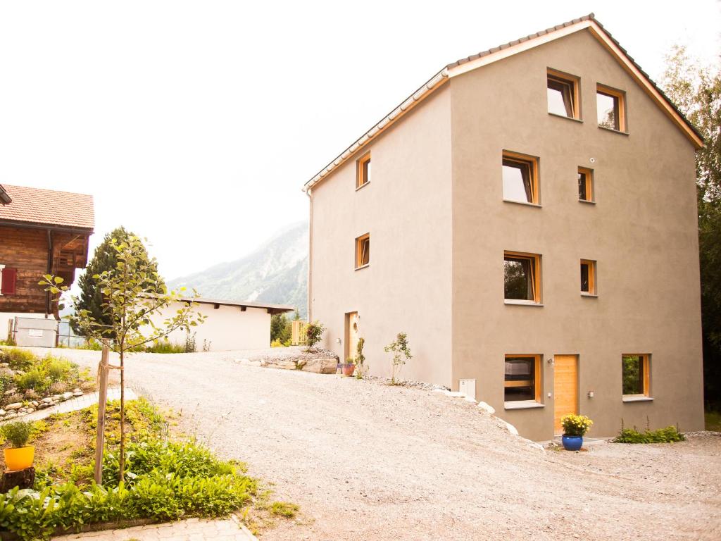 una casa al lado de un camino de tierra en Nangijala Guest House, en Disentis