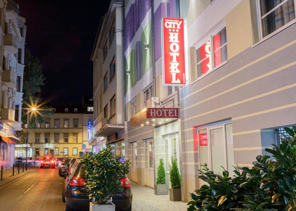 un bâtiment avec un panneau d'hôtel sur le côté d'une rue dans l'établissement City Hotel Wiesbaden, à Wiesbaden