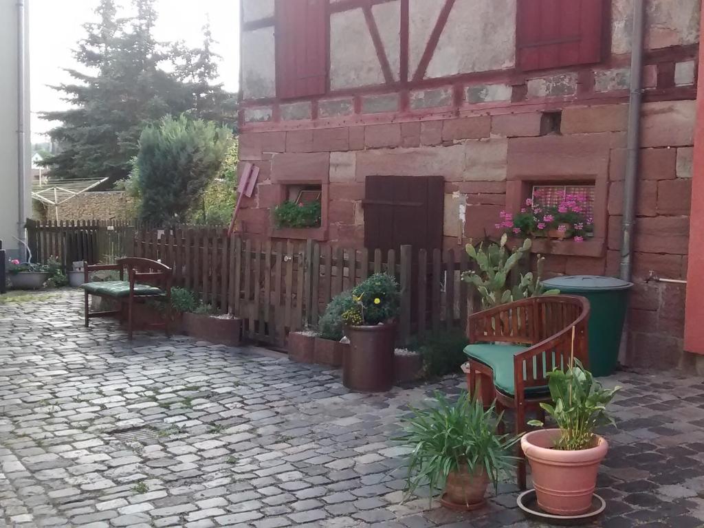 une terrasse avec bancs, plantes en pot et clôture dans l'établissement Landhauspension Rank, à Bad Berka