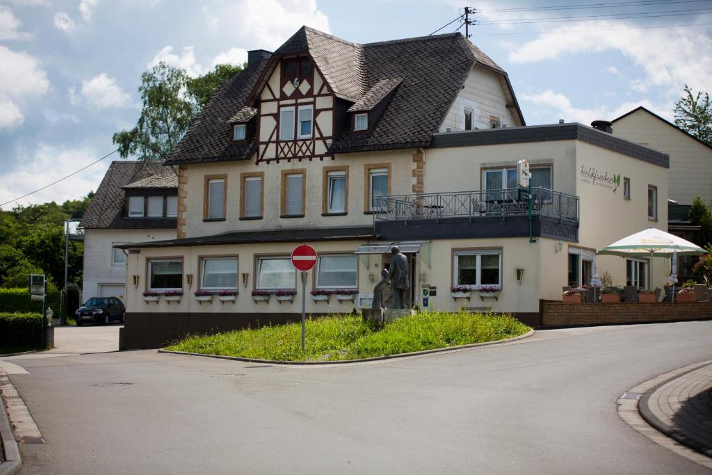 een groot huis met een stopbord ervoor bij Hotel Waldfrieden in Emmelshausen