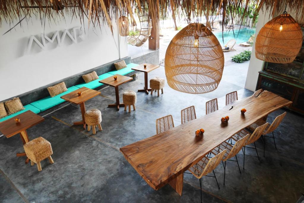 einen Blick über ein Restaurant mit Holztischen und Stühlen in der Unterkunft Amar Boutique Hotel in Canggu