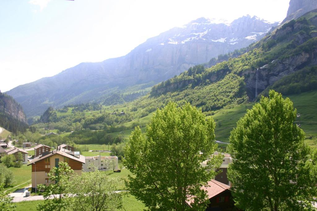 ein Dorf in einem Tal mit Bergen im Hintergrund in der Unterkunft Alfa Appartements Superior in Leukerbad