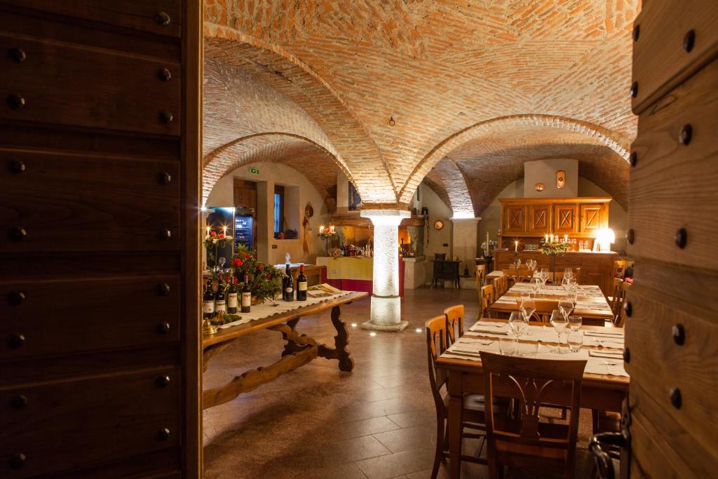 un ristorante con un lungo tavolo e bottiglie di vino di A' la Table du Sommelier Chambres d Hôtes & Restaurant a Saint Vincent