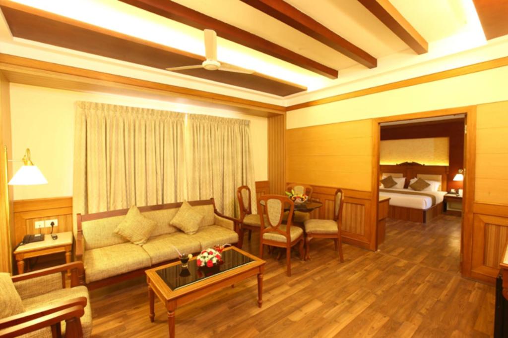 sala de estar con sofá y dormitorio en Hotel Airlink Castle, en Nedumbassery