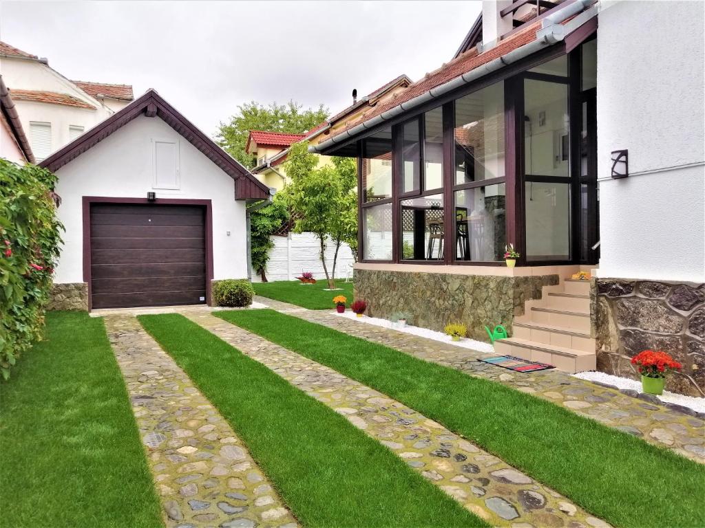 een huis met een garage en een grasveld bij Tudor Central House Sibiu in Sibiu