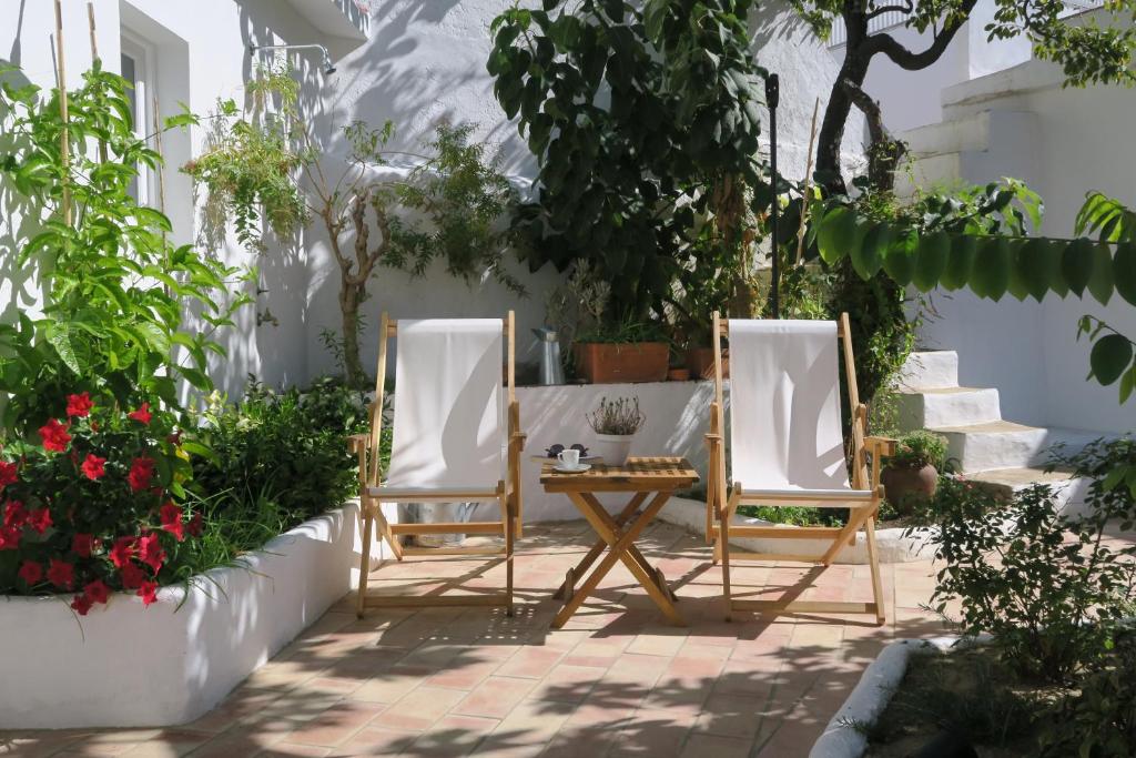 2 chaises et une table dans un jardin dans l'établissement Azul Sul, à Tavira