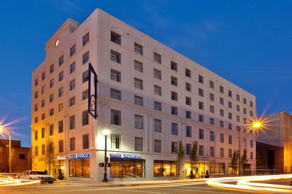 - un grand bâtiment blanc dans une rue de la ville la nuit dans l'établissement Hotel Indigo Baton Rouge Downtown, an IHG Hotel, à Bâton-Rouge