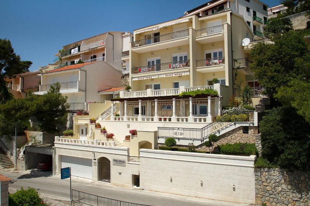 a large building with balconies on the side of a street at Villa King Apartments in Brela