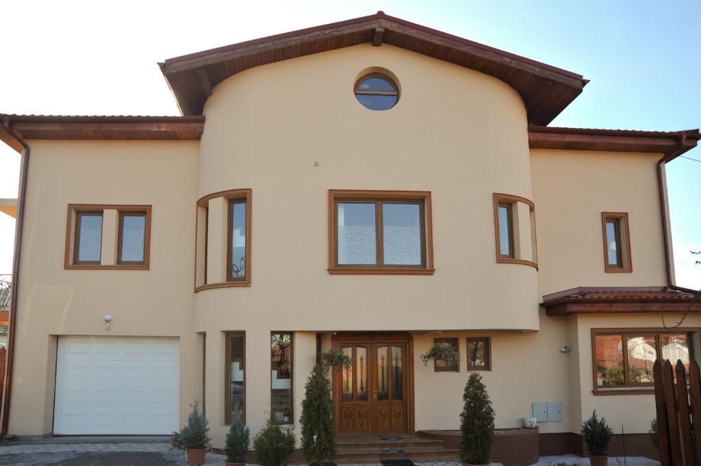 a large white house with a brown roof at Pensiunea Kenza in Târgu-Mureş