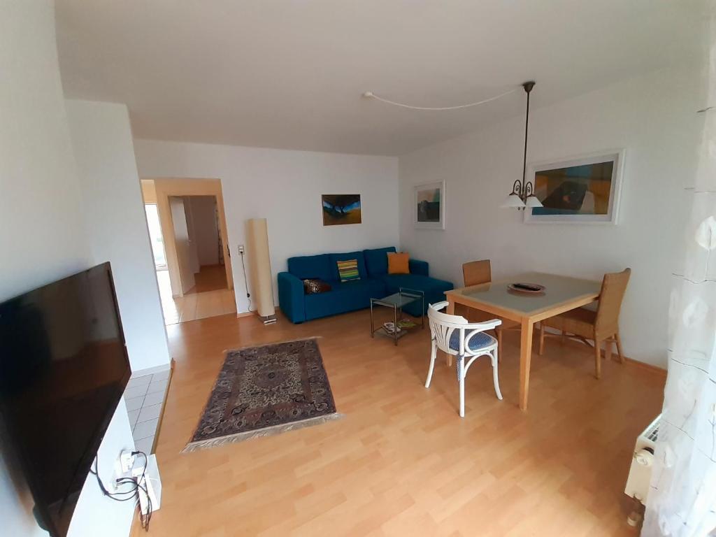 a living room with a blue couch and a table at Wohnung im Herzen von Ettlingen in Ettlingen