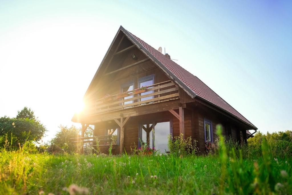 dom na wzgórzu ze słońcem za nim w obiekcie Chalet avec vue unique w mieście Kętrzyn