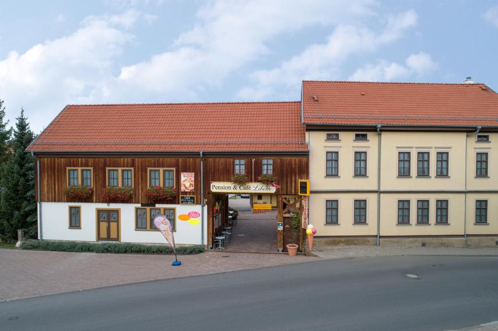 un gran edificio con techo rojo en Pension-Café-Libelle, en Elxleben bei Arnstadt