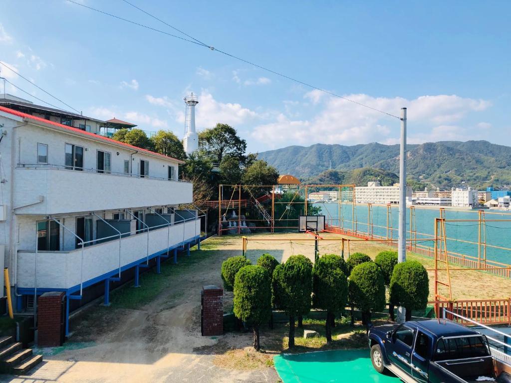 un'auto parcheggiata in un parcheggio accanto a un edificio di Sea Side Hostel Light House a Onomichi