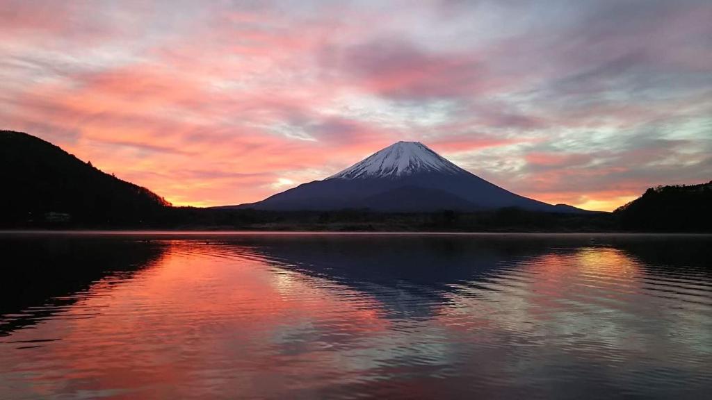 uma montanha com um reflexo na água ao pôr do sol em Shoji Mount Hotel em Fujikawaguchiko