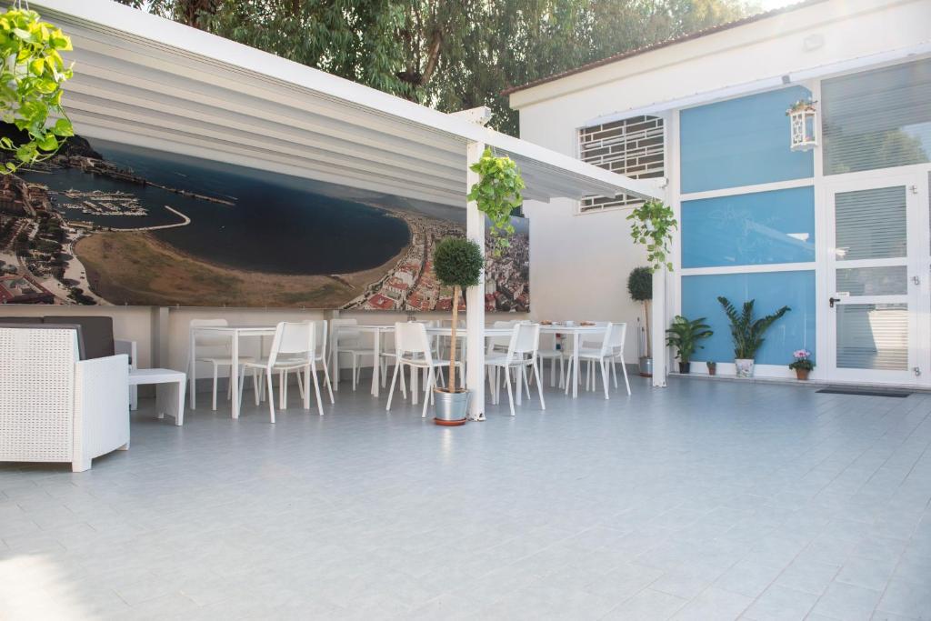 een patio met witte stoelen en een schilderij aan de muur bij Stabia Dream Rooms in Castellammare di Stabia