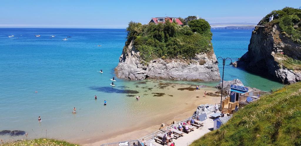 uma praia com um monte de pessoas na água em OYO Minerva Guesthouse em Newquay