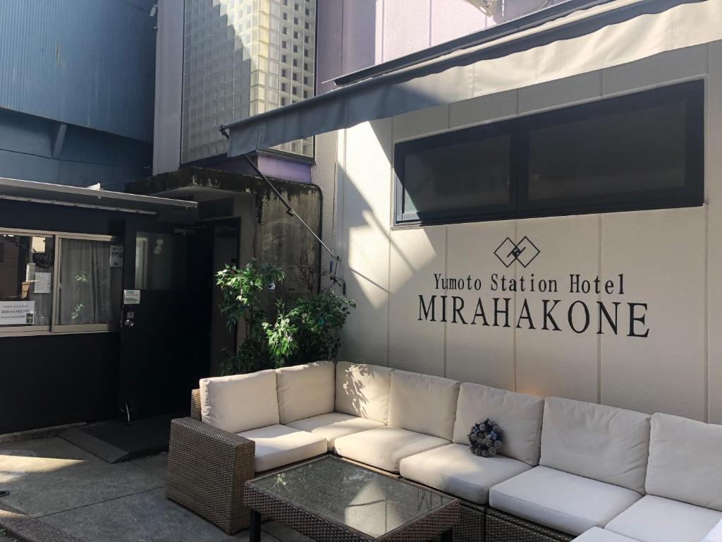 箱根町にあるユモトステーションホテル MIRAHAKONEのマリオットステーションホテルの外に座る白いソファ