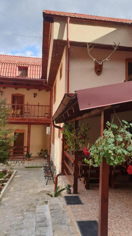 une cour d'un bâtiment avec une table et des bancs dans l'établissement Pensiunea LUKA Slanic Moldova, à Slănic-Moldova