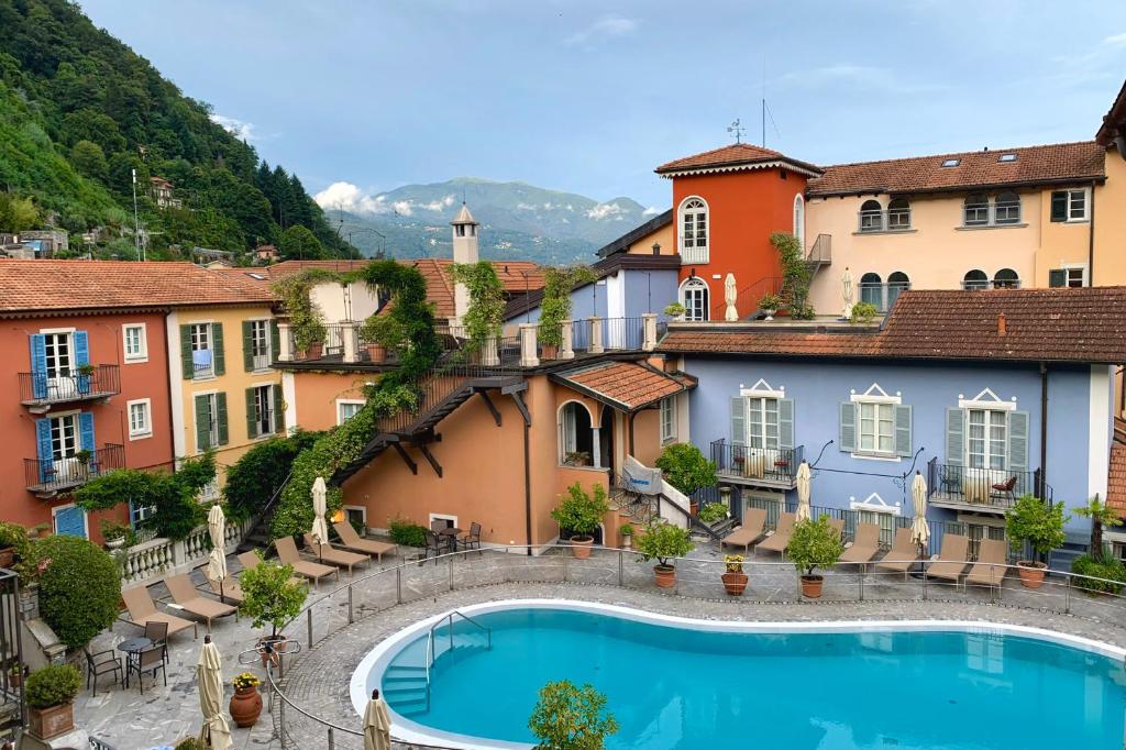 a resort with a swimming pool in front of buildings at Residenza dei Fiori in Cannero Riviera