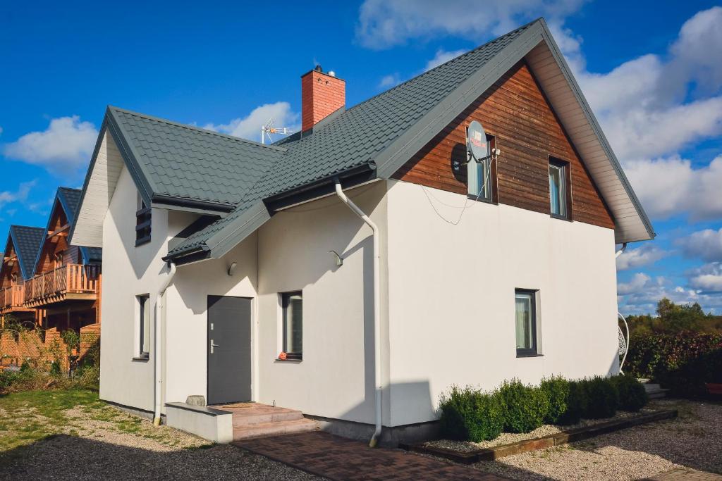 ein weißes Haus mit braunem Dach in der Unterkunft Gama Spa in Władysławowo