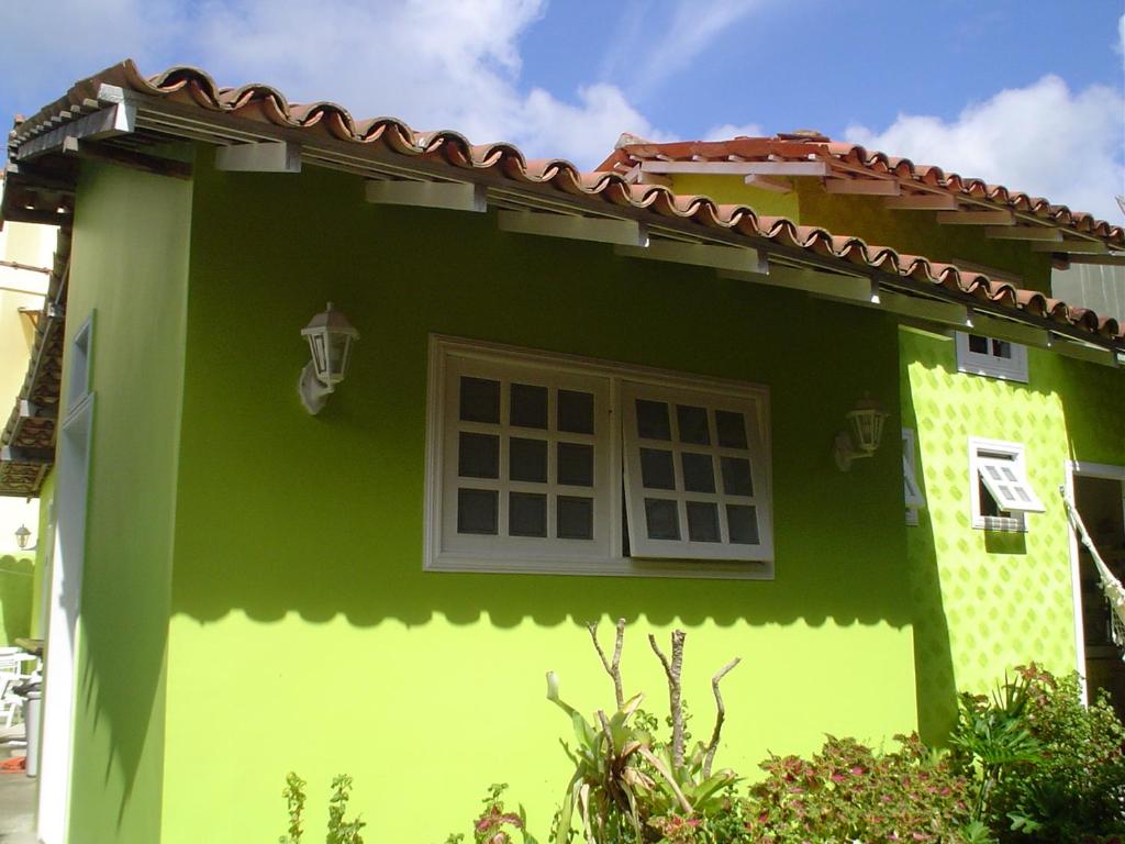 Maison verte et blanche avec fenêtre dans l'établissement SUÍTES Caminho do Mar, à Abraão