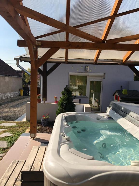 a hot tub on a patio with a pergola at Panni Vendégház in Egerszalók