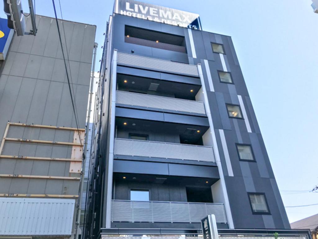 um edifício com um sinal na lateral em HOTEL LiVEMAX Chiba Soga-Ekimae em Chiba