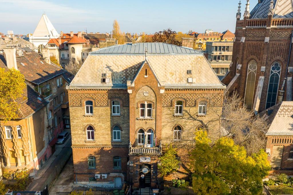 ein altes Backsteingebäude mit einem Uhrturm in einer Stadt in der Unterkunft Dominik Panzió in Budapest