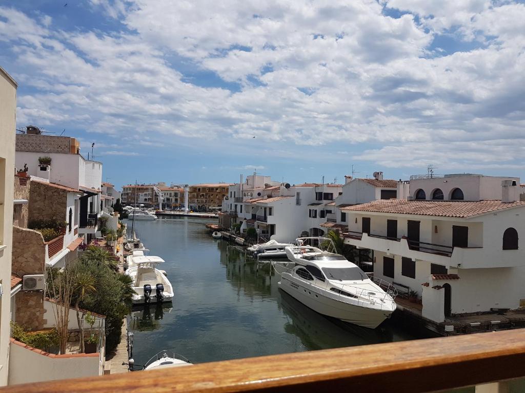 een groep boten aangemeerd in een kanaal met gebouwen bij Magnífico apartamento junto al canal principal. in Empuriabrava