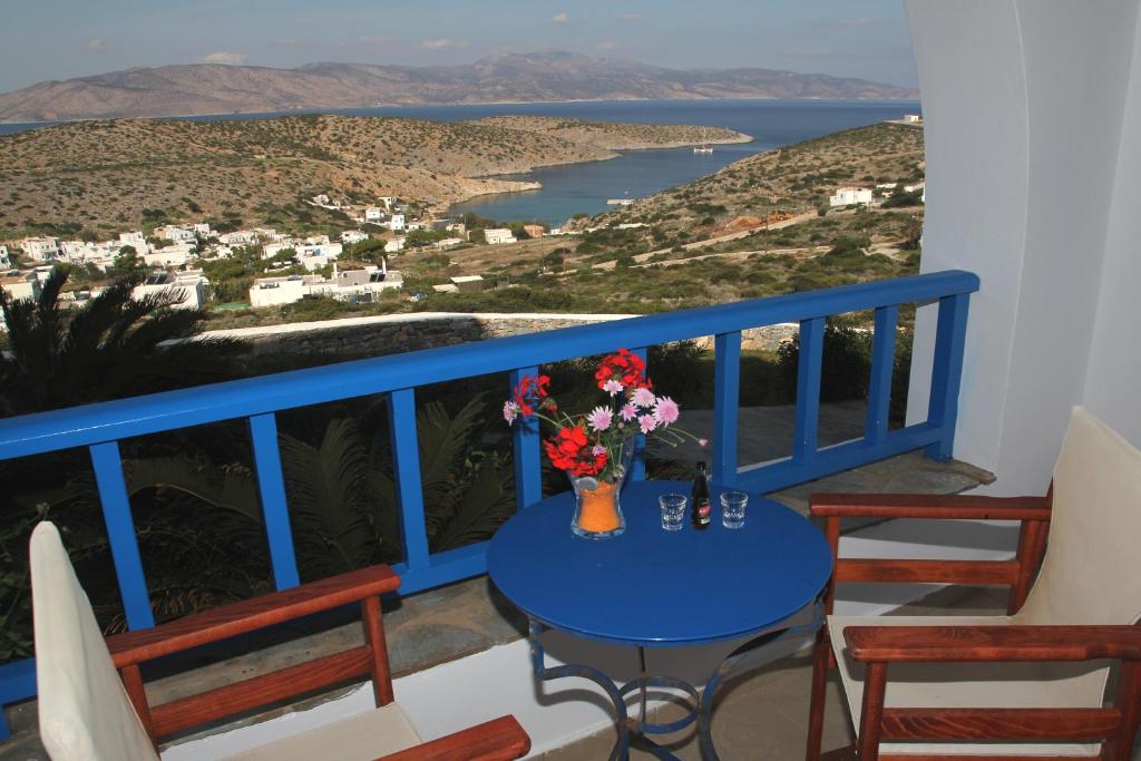 une table bleue avec un vase de fleurs sur un balcon dans l'établissement Aiolos Hotel, à Iraklia