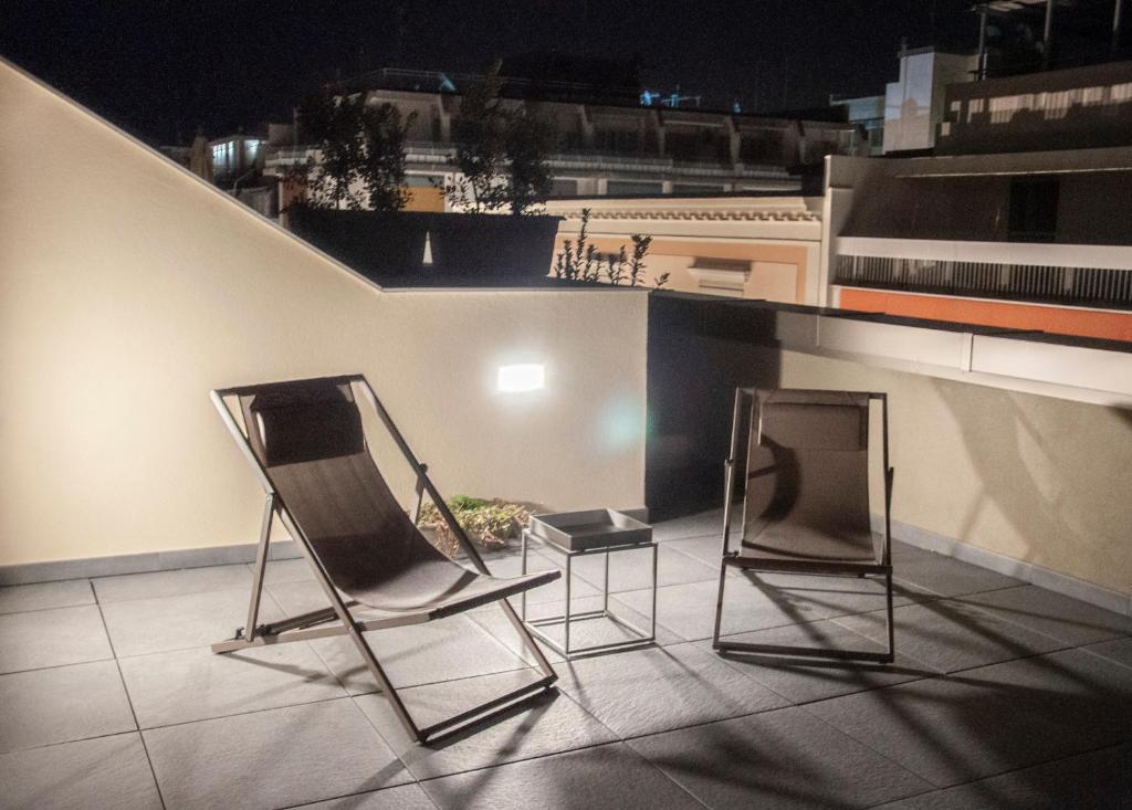 two chairs and a tv on a rooftop at night at NICOLA'S APARTMENTS in Bari