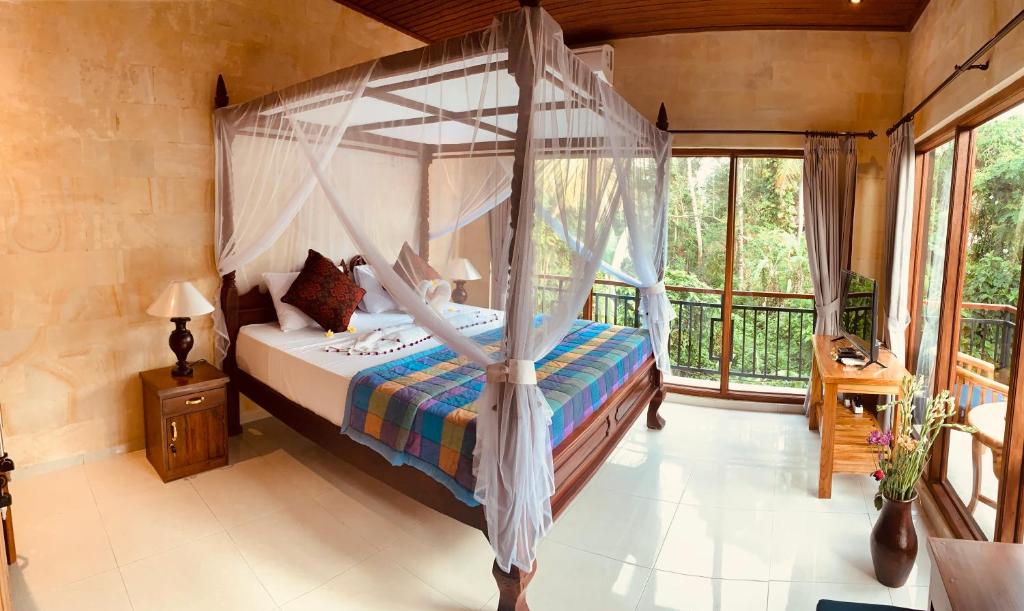 1 dormitorio con cama con dosel y balcón en Sari House Ubud, en Ubud