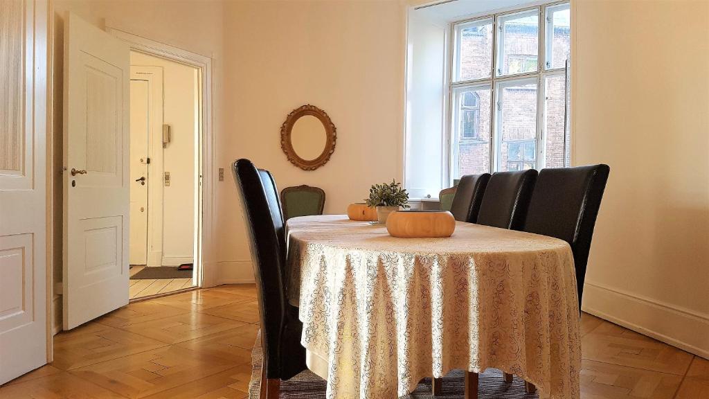 un comedor con una mesa con una calabaza. en Aaboulevard Apartment, en Copenhague