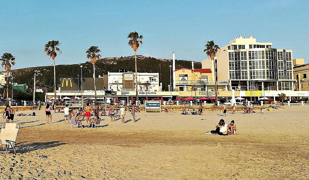 un gruppo di persone su una spiaggia con palme di Hostería Miramar a Piriápolis