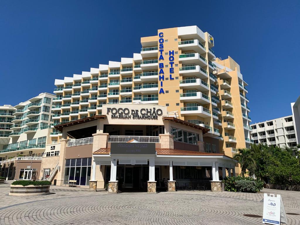 a large building with a sign in front of it at Costa Bahia Hotel Paseo Caribe in San Juan