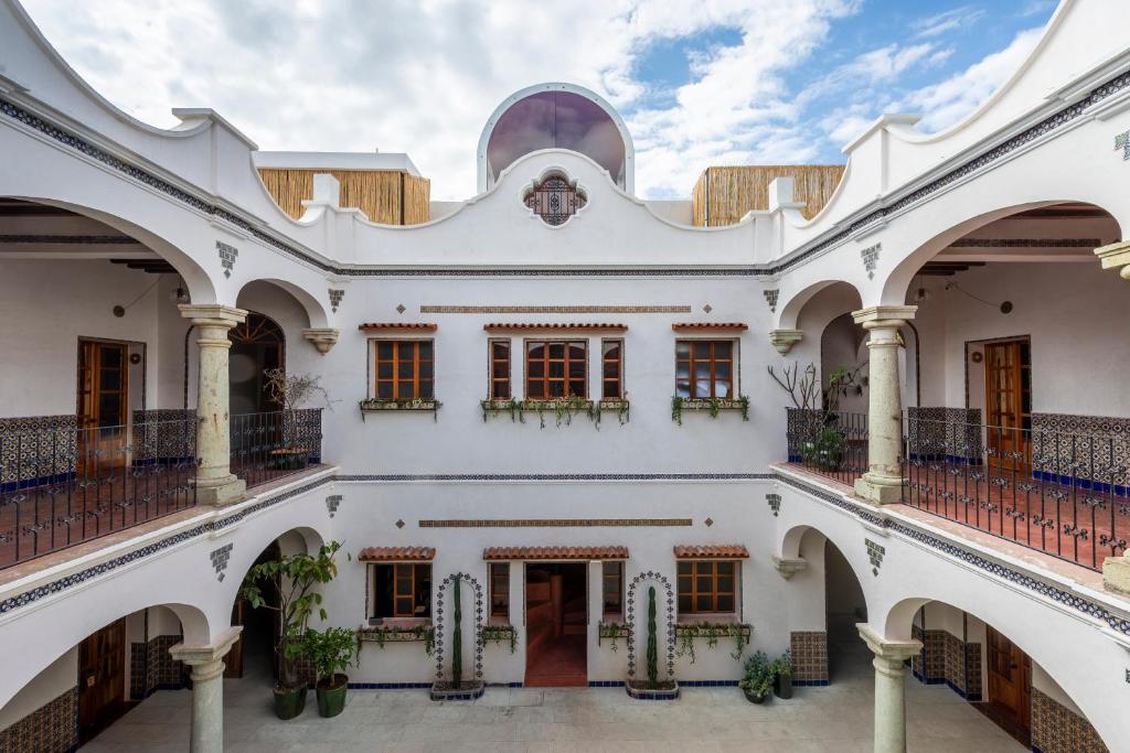 einen Außenblick auf ein weißes Gebäude mit Balkonen in der Unterkunft Grana B&B in Oaxaca de Juárez