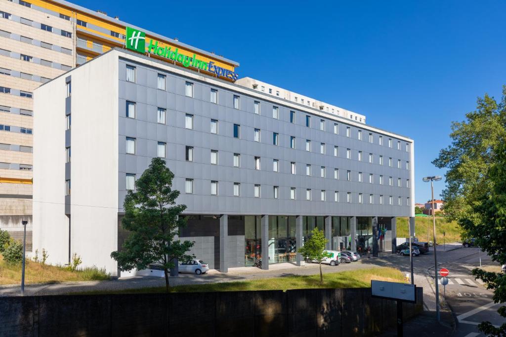 um grande edifício branco com um cartaz em Holiday Inn Express Porto Exponor, an IHG Hotel em Leça da Palmeira